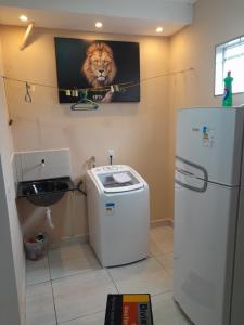 baño con nevera y una foto de un león en Hospedagem do Elias, en Cuiabá