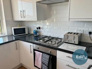 a kitchen with a stove top oven next to a microwave at 2 Br Flat Free Parking Great Location in Southampton