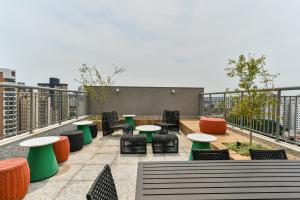 a patio with tables and chairs on a roof at Studio Prime in Sao Paulo
