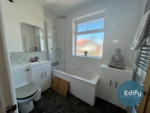 a bathroom with a toilet and a tub and a sink at 2 Br Flat Free Parking Great Location in Southampton