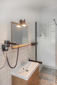 a bathroom with a sink and a shower and a mirror at Neu möbliertes 1 - Zimmerapartment mitten in der Natur in Neu Gaarz