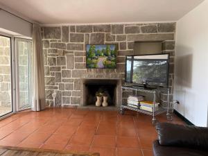 a living room with a stone fireplace and a tv at Chalet con piscina en Torrelodones in Torrelodones