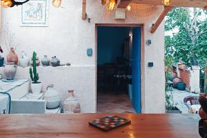 Zimmer mit einem Tisch, Vasen und einer Tür in der Unterkunft "La Cabane de Thau" avec vue imprenable sur Sète in Loupian