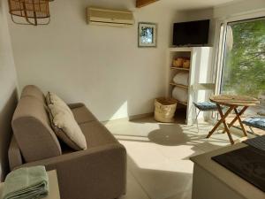 ein Wohnzimmer mit einem Sofa und einem Tisch in der Unterkunft "La Cabane de Thau" avec vue imprenable sur Sète in Loupian