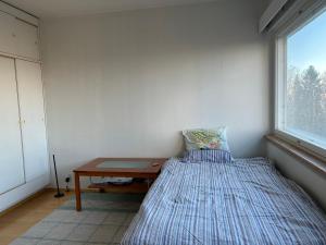 um quarto com uma cama, uma mesa e uma janela em An entire flat 60m2 with a balcony in Itakeskus of Helsinki em Helsínquia