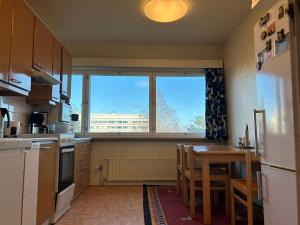 uma cozinha com uma mesa e uma grande janela em An entire flat 60m2 with a balcony in Itakeskus of Helsinki em Helsínquia