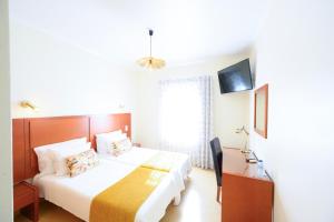 a hotel room with a bed and a television at Hospedaria Recomeçar in Santa Cruz
