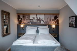 - une chambre avec un lit et 2 oreillers blancs dans l'établissement 4Hafenzeiten - Ferienwohnung NIE 10 Gertrud II, à Niendorf