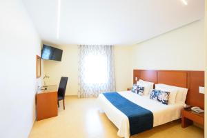 a hotel room with a bed and a desk at Hospedaria Recomeçar in Santa Cruz