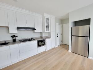 uma cozinha com armários brancos e um frigorífico de aço inoxidável em Room for rent with own bathroom em Hartford
