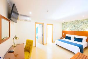 a hotel room with a bed and a desk at Sea & Sun Hospedaria Recomeçar in Torres Vedras
