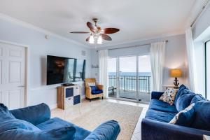 sala de estar con sofá azul y TV en Crystal Shores West Unit 208, en Gulf Shores