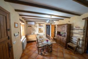 a kitchen with a table and chairs in a room at farmhouse la Curiosa in Laroya