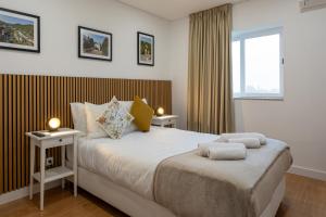 a bedroom with a large bed with two tables at Guest House A Loja do Cantoneiro in Albergaria-a-Velha
