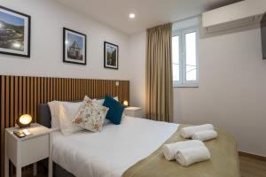 ein Schlafzimmer mit einem großen weißen Bett mit Kissen in der Unterkunft Guest House A Loja do Cantoneiro in Albergaria-a-Velha
