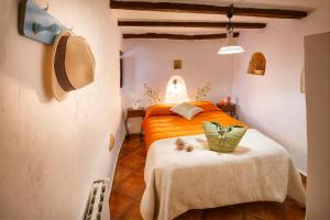 a bedroom with an orange bed and a table at farmhouse la Curiosa in Laroya