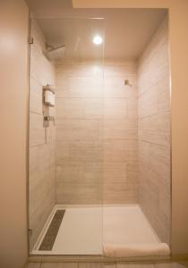 a shower with a glass door in a bathroom at Meeting House in Falls Church