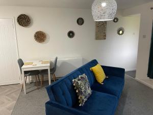 uma sala de estar com um sofá azul e uma mesa em The Uxbridge Suite em Hednesford