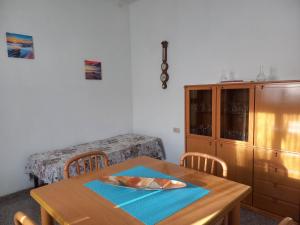 une salle à manger avec une table et une armoire dans l'établissement Casa di Adele con giardino privato a 150 mt dal mare, à Senigallia
