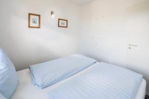 ein weißes Bett mit zwei Kissen darüber in der Unterkunft Haus Bielefeld Ferienwohnung 29 in Norderney