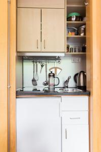 eine Küche mit weißen Schränken und einem Waschbecken in der Unterkunft Haus Bielefeld Appartement 24 in Norderney