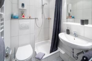 La salle de bains blanche est pourvue de toilettes et d'un lavabo. dans l'établissement Haus Bielefeld Ferienwohnung 14, à Norderney