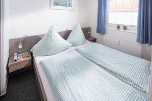 Schlafzimmer mit einem Bett mit blauen und weißen Kissen in der Unterkunft Haus Bielefeld Ferienwohnung 13 in Norderney
