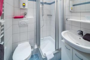 ein Bad mit einer Dusche, einem WC und einem Waschbecken in der Unterkunft Haus Bielefeld Ferienwohnung 13 in Norderney