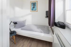 a small room with a bed and a window at Haus Bielefeld Ferienwohnung 10 in Norderney
