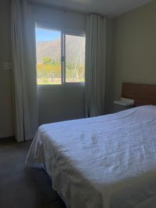 um quarto com uma cama branca e uma janela em Cabaña em La Rioja