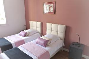 ボルドーにあるGrand Lebrun - Appartement 3 chambres avec ascenseur - Caudéranのベッドルーム1室(ピンクの枕が付くベッド2台付)