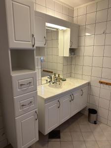 a white bathroom with a sink and a mirror at Edith Huset in Moskenes
