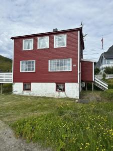 a large red and white house with a yard at Edith Huset in Moskenes