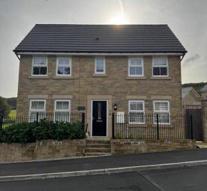 a brown brick house with a black roof at Peak View - Modern Cottage in Buxton