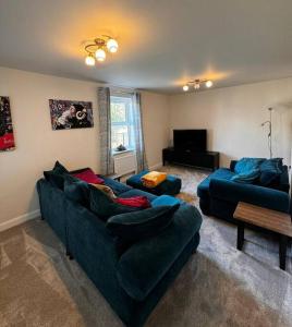 a living room with two couches and a television at Peak View - Modern Cottage in Buxton