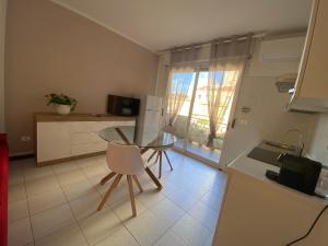 een keuken met een glazen tafel en stoelen in een kamer bij Residence La Peonia in Sassari