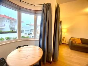 a living room with a table and a window at Ericeira Panoramic Sea View Apartments in Ericeira
