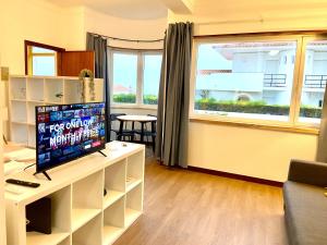 a living room with a tv and a window at Ericeira Panoramic Sea View Apartments in Ericeira