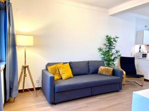a blue couch with yellow pillows in a living room at Ericeira Panoramic Sea View Apartments in Ericeira
