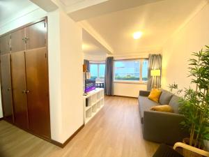 a living room with a couch and a large window at Ericeira Panoramic Sea View Apartments in Ericeira