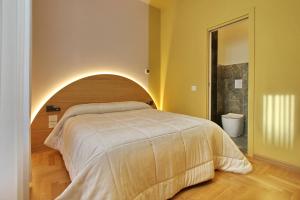 um quarto com uma cama grande e uma cabeceira arqueada em Dreaming Rome Suites em Roma