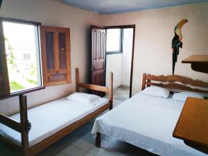 two beds in a room with a table and a window at Divino Niño Hotel in Leticia