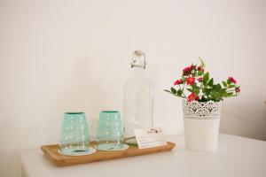 uma garrafa e dois copos e um vaso com flores em Monte Oliva - Turismo Rural em Cerro da Zorra