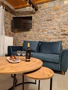 a living room with a couch and a table with wine glasses at Villas Kertezi in Kalavrita