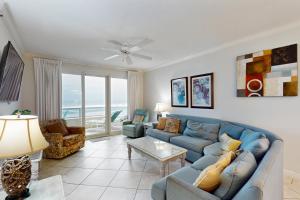 a living room with a blue couch and a table at Enclave 304 in Orange Beach