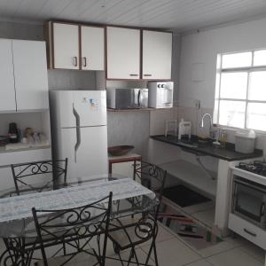 a kitchen with a refrigerator and a table and chairs at Cs 3 qts, Brasília, Taguatinga. in Brasília