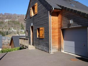 a black house with a garage and a driveway at Chalet Mont-Dore, 5 pièces, 8 personnes - FR-1-608-223 in Le Mont-Dore