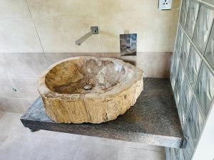 y baño con ducha y bañera grande de madera. en Villa Alexandra en Antananarivo