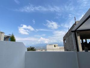 een wit hek voor een huis bij Hermosa Suite para largas estadías con parqueadero in Quito