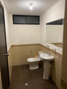 een badkamer met een toilet en een wastafel bij Hermosa Suite para largas estadías con parqueadero in Quito